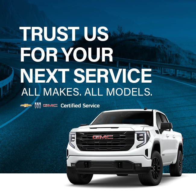 White GMC truck on a road with text promoting certified vehicle service for all makes and models.