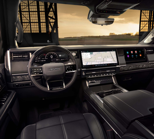 Luxurious SUV interior with a digital dashboard, touchscreen navigation, and a sunset view through the windshield.