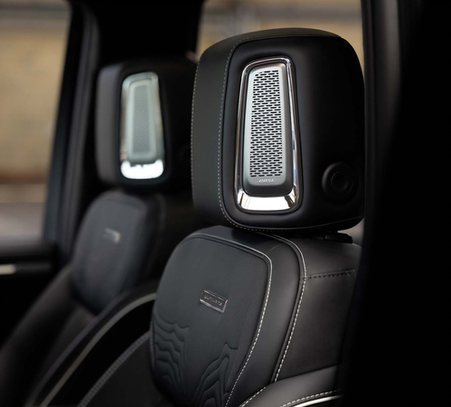 Close-up of luxury car's leather seats with integrated speakers in the headrests.