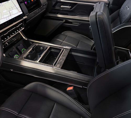 Modern car interior with black leather seats, a touchscreen display, and a center console featuring cup holders.